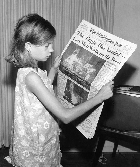 Girl reading newspaper article